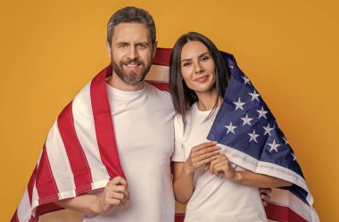 Bayrağı olan mutlu bir Amerikan çifti. Amerikan bayrağıyla gururla poz veren bir çift. Amerikan bayrağı taşıyan çiftlerin vatanseverliği. Bayrağa sarılı Amerikalı ruh çiftimizi kutluyoruz..