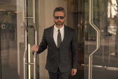 Başarılı bir iş adamı ofise giriyor. Ofis kapısında olgun bir girişimci. Takım elbiseli Amerikalı işadamı ofis binasını terk ediyor. CEO ofise giriyor. İş adamı liderliği.