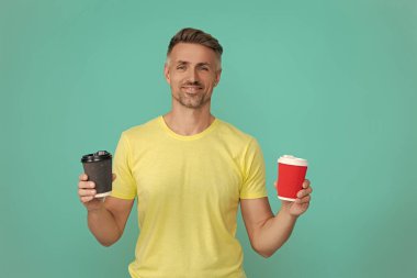 Sıcak bir sabah, rahatla. Kahveci adamla kahve molası. Olgun bir adam mavi üzerine kafeinsiz kahve fincanı seçer. Sabah kahvesi vakti. Kafeinsiz yaşam tarzı konsepti. Kafeinsiz içiyorum. Çay içen adam.