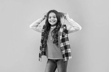 Pembe arka planda kıvırcık saçlı gülümseyen çocuk, sıradan moda.