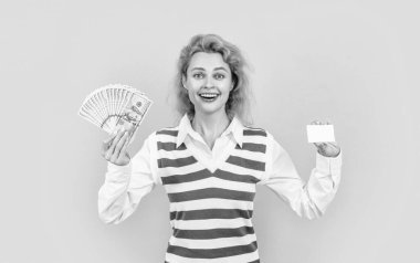 kızıl saçlı zengin kadın, para ve kart ile renklendirilmiş. Parası olan zengin bir kadın sarı arka planda izole edilmiş. Stüdyoda parası olan zengin bir kadın. Zengin ve zengin bir kadının fotoğrafı..