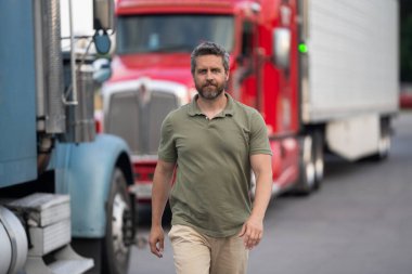 Kamyonun önünde yakışıklı bir şoför. Kamyon sahibi. Kamyon şoförü. Kamyon kamyonunun yanında bir erkek kamyon şoförü. Nakliye araçları. Yarı kamyon aracı. İspanyol kamyoncu adam. Mesleki meslek.