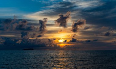 Deniz sahilinde gün batımı, günbatımı gökyüzü ve gemiyle deniz manzarası. Denizin üzerinde deniz manzaralı altın gün doğumu. Doğa konsepti. Güzel bir alacakaranlık. Sabahın erken saatlerinde deniz üzerinde gün doğumu. Akdeniz.