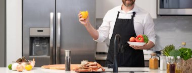 Hispanic man standing in kitchen preparing sea food. Millennial man cook tasty crab leg. Healthy food diet. Man cook tasty meal. Home menu with seafood food. Man cook cooking at kitchen. Cropped view. clipart