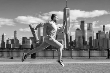 Sporcu koşucu ya da koşucu. Spor takım elbiseli bir adam koşu yapıyor. Manhattan 'da koşan adam. New York 'ta sabah sporu koşucusu. Spor antrenmanında koşan koşucu. Fiziksel uygunluk.