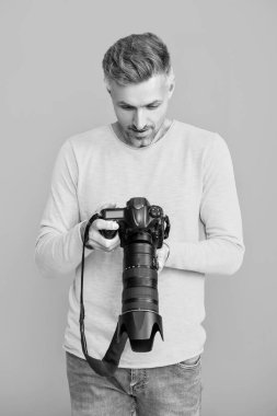 Çekim seansı. Fotoşop. Fotoğraf çeken bir adam. Kamerayla fotoğraf çekmek. Mavide izole edilmiş erkek fotoğrafçı. Fotoğrafçı, fotoğraf makinesini tut. Profesyonel fotoğrafçılık. Makro fotoğrafçılık.