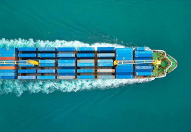 Yük konteynırı kargo gemisine yüklendi. Hava görüntülü kargo gemisi limana giriyor. Kargo işi. Konteyner gemisi. Nakliye lojistiği. Ticari nakliye. Kargo gemisi denizde, hava manzaralı..