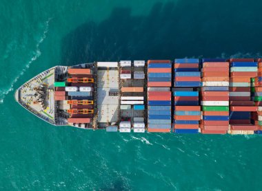 Kargo işi. Konteyner gemisi. Nakliye lojistiği. Ticari nakliye. Kargo gemisi denizde, hava manzaralı. Kargo gemisinde nakliye konteynırı. Hava görüntülü kargo gemisi limana giriyor. Ağır görev gemisi..