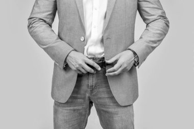 Takım elbiseli ve kot pantolonlu adam. Sıradan bir adam. Kesik manzaralı. Resmi giysili adam için erkek aksesuarı. Erkek giyim konsepti. Kot pantolon ve kemer giyen erkekler için erkek giyimi.