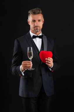 Yürekli bir adam. Sevgililer günün kutlu olsun. Benim sevgilim ol. Sevgi dolu bir adam siyahta izole edilmiş. Romantik hediyelere bayılırım. Smokinli ve şampanyalı zengin bir adam. Sevgililer günü indirimi. Zengin adam sevgililer gününü kutluyor..