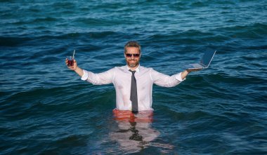 Serbest çalışan bir adam çevrimiçi. Başarılı bir iş. Yaz denizinde bir iş adamı. Çevrimiçi serbest çalışma. Dizüstü bilgisayarı olan bir işadamı. Dizüstü bilgisayarı olan bir iş adamı. Seyahat ve iş.