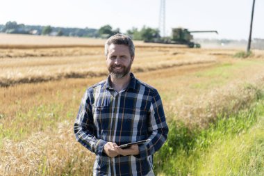 Tarlada tableti olan çiftçi tarımcı adam. Modern tarımın teknolojisi. Tarlada tabletle çalışan çiftçi. Tablet çekli İspanyol çiftçi. Hasat yönetimi.