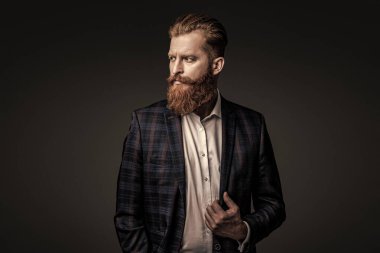 Bespoke takımı. Özel dikim erkek giysisi giymiş sakallı adam. Özel dikim kıyafet giyen bir iş adamı. Şık takım elbiseli bir iş adamı. Resmi terzilik kıyafeti. Erkek giyim kuşamı. Smokin ceketi..