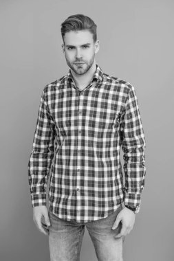 Gri yolda izole edilmiş bir adam. Kareli gömlek giyen milenyum adamı. Milenyum erkeğinin gündelik tarzı. Sıradan bir tişörtle genç bir adamın portresi. Tıraşsız adamın şık bir portresi. Tarz Soğukluğu.