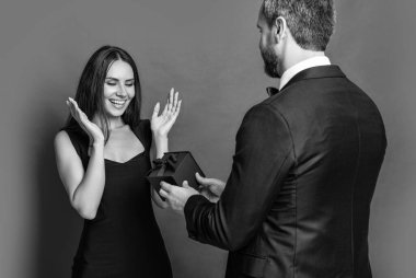 Hediye. Erkek kadına evlenme teklif ediyor. Erkek, sevgililer günü için kadınlara hediye kutusu verir. Sevgililer günün kutlu olsun. Aşık çift kırmızıda izole edilmiş. Hediyeli romantik evlenme teklifi. Aşk teklifi..