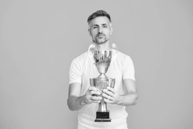 Şampiyonluk kupasını tutan adam. Sporda kazanan sporcu. Başarılı bir spor. Olgun bir sporcu gerçek bir şampiyon. Başarıyı kutluyoruz. Şampiyon. Spor başarısı ve zafer. Kendisiyle gurur duyuyor..