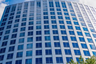 Pencereli bir ofis binasının mimarisi. Perspektif gökdeleni. Ticari mimari. İş gökdeleni binası. Mimari inşaat sektörü. Cam gökdelen. Şehir mimarisi.