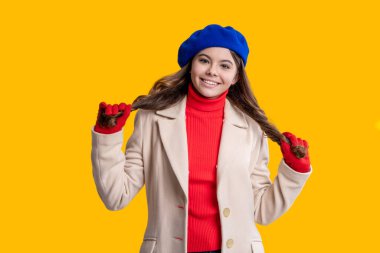 Sonbahar moda kızı. Moda ve şık genç kız gülümsüyor. Gençler için sonbahar moda tarzı. Sonbahar tarzının modaya uygun portresi. Sonbahar montlu kız sarıda soyutlanmış. Genç kız bereli, uzun saçlı..