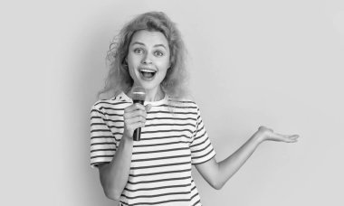 Şarkıcı kız, sarı arka planda kopya alanı ile izole edilmiş. Genç şarkıcı kız stüdyoda şarkı söylüyor. Mikrofonlu kız şarkıcı.