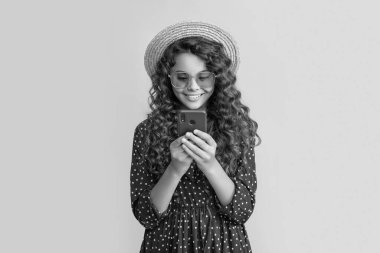 Sarı arka planda telefonda konuşan kıvırcık saçlı mutlu çocuk..