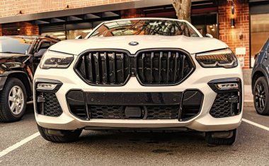 New York City, ABD - 15 Mart 2024: BMW X6 modern beyaz araba açık hava, alçak görüş.