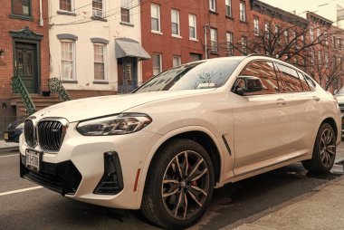 New York City, ABD - 1 Nisan 2024: BMW X4 lüks geçiş aracı açık hava, köşe manzaralı.