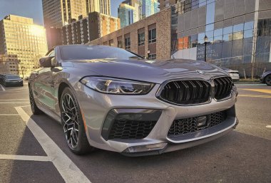 New York, ABD - 11 Mart 2024: BMW M8 üstü açık lüks araba, köşe manzaralı.