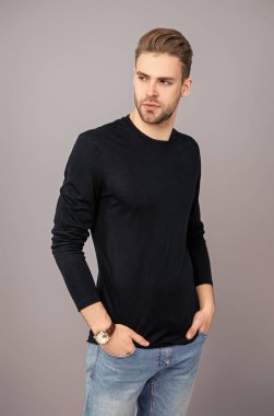 Erkek derisi. Adamın şık bir saç kesimi var. Moda saç stili olan bir adam. Sıradan erkek tarzı. Beyazlı genç bir adam gri yolda izole edilmiş. Kendine güvenen adam portresi. Erkeklerin cilt bakımı. Dinamik Altuzağı.