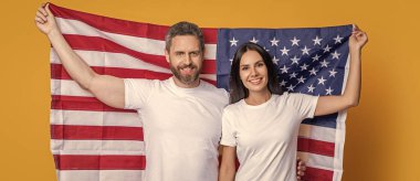 Bağımsızlık Günü 'nde Amerikalı bir çift. Amerikan çifti Bağımsızlık Günü ruhunu bayraklarla kucaklıyor. Bağımsızlık Günü tatili. Amerikan bayrağı taşıyan çift. Bağımsızlığı onurlandıran vatansever çift.