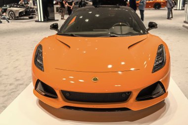 New York, ABD - 27 Mart 2024: Lotus Emira spor araba turuncu renkli New York Uluslararası Otomobil Fuarı, ön manzara.
