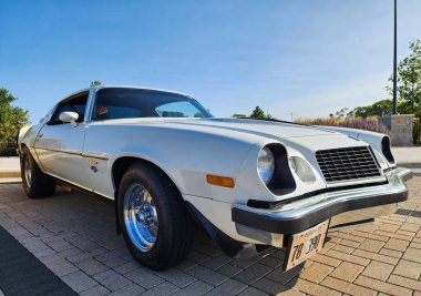 Park Ridge, Illinois, ABD - 21 Ağustos 2024: Otomobil fuarına park edilmiş beyaz araba, köşe manzaralı. Chevrolet Camaro 1976 eski araba. Chevrolet Camaro 'nun beyaz arabası. Chevy Camaro.