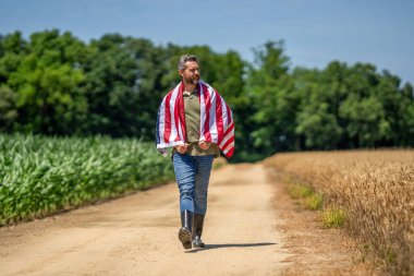 Amerika 'nın Bağımsızlık Günü. 4 Temmuz. Amerikan İşçi Bayramı. Amerikan bayrağı ve çiftçi adam. ABD bayrağı. Bağımsızlık Günü. Sahadaki adam. Tarlada Amerikan bayrağı taşıyan adam.