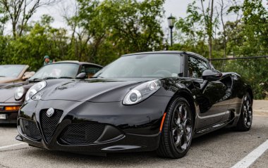 Chicago, Illinois - 29 Eylül 2024: 2015 Alfa Romeo 4C Coupe siyah rengi. P2015 Alfa Romeo 4C Coupe sokağa park etmiş. Köşeden bak. 2015 Alfa Romeo 4C Coupe Chicago 'da