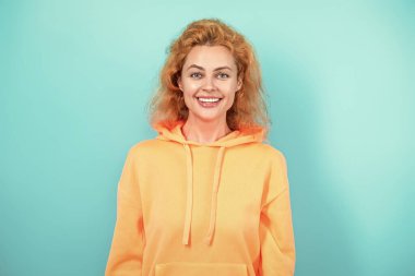 Mavi üzerine kapüşonlu giyen kadın. Moda modeli. Şık kapüşonlu kızıl saçlı kız. Sıradan kapüşonlu, şık, beyaz bir kadın. Modayla ilgilenen kız modaya uygun ve parlak görünüyor. Kapüşonlu kumaş.