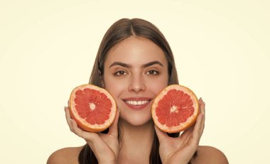 Sağlıklı greyfurtlu genç bir kadın. C vitamininin faydaları cildini beyazla izole edilmiş vitaminle doldurur. Cilt bakımı ve diyet. Gençlik ve güzellik. Genç kız sağlıklı bir ışıltı için detoks yapıyor. Yiyecek ya da sağlık..
