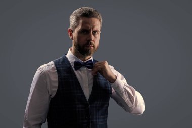 Garson. Smokinli erkek giysili adam Griler 'de izole edilmiş. Resmi erkek giyim sektöründe karizmatik bir adam. Yakışıklı garson adam smokin giyer. Şık smokin papyonu. Papyonlu garson servis yapmaya hazır. Reklam..