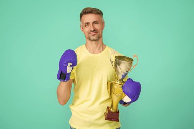 Başarılı bir spor. Olgun boksör şampiyonu. Başarıyı kutluyoruz. Boks şampiyonu. Spor başarısı ve zafer. Şampiyonlar kupası. Boks sporunu kazanan sporcu. Spor kupası.