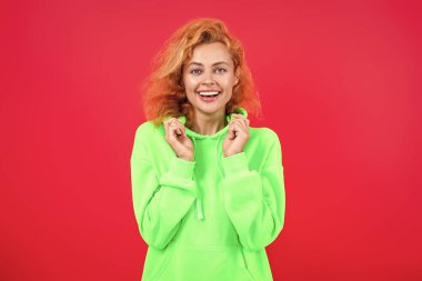 Tarz sahibi beyaz kadın ya da kızıl saçlı manken. Pembe üzerine izole edilmiş şık ve modaya uygun kapüşonlu parlak renk..