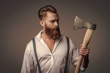 Antika pantolon askılı, eski tip bir gaddar adam. Askılık giymiş vahşi bir adam gride izole edilmiş. Saçları kızıl saçlı, olgun bir adam. Acımasız erkek modası. Erkek vahşeti..