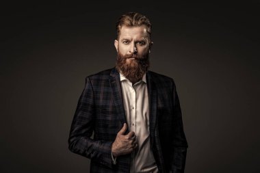 Özel dikim kıyafet giyen bir iş adamı. Şık takım elbiseli bir iş adamı. Resmi terzilik kıyafeti. Erkek giyim kuşamı. Bespoke takımı. Özel dikim erkek giysisi giymiş sakallı adam. Resmi giysi.