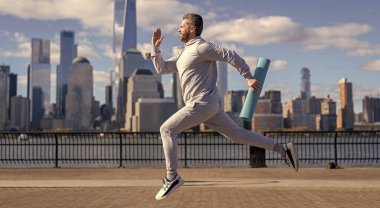 New York 'a doğru koşan sporcu. Sporcu adam aktif giyinmek için koşuyor. Sporcu koşucu. Manhattan 'da spor habercisi. Spor başarısı.