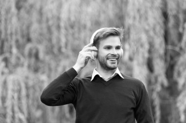 positive young handsome man listen music in headphones outdoor.