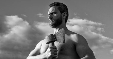 Baltalı üstsüz adam. Beyaz adam, baltayı tut. Arka planda vahşi bir adam. güçlü pazılar..