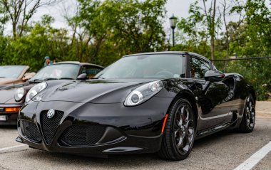 Chicago, Illinois - 29 Eylül 2024: 2015 Alfa Romeo 4C Coupe siyah rengi. P2015 Alfa Romeo 4C Coupe sokağa park etmiş. Köşeden bak. 2015 Alfa Romeo 4C Coupe Chicago 'da