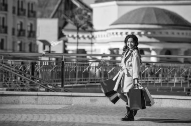 Sonbahar alışverişçisi kız gardırobunu mevsimlik satışlarla değiştiriyor. Alışveriş torbaları açık havada alışveriş yapan bir genç. Sonbahar montlu genç kız. Uzay afişini kopyala. Sonbahar alışverişçisi kız şehirde butikleri keşfediyor..