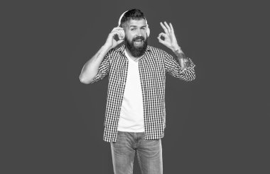 Olumlu sakallı adam kulaklıkla müzik dinliyor. Tamam.
