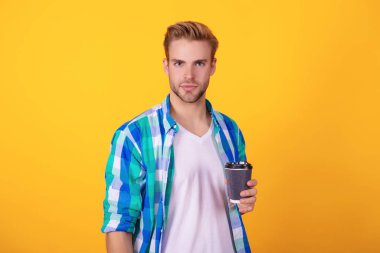 Çay içen adam. Sıcak bir sabah. Evde kahve molası. Millennial Man 'in sarı kahve fincanı var. Sabah kahvesi vakti. Yaşam tarzı konsepti. Espresso içiyorum..