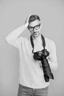 Fotoğraf çeken bir adam. Kamerayla fotoğraf çekmek. Mavide izole edilmiş erkek fotoğrafçı. Fotoğrafçı, fotoğraf makinesini tut. Profesyonel fotoğrafçılık. Çekim seansı. Fotoşop. ISO duyarlılığı.