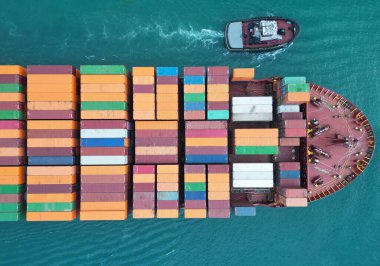 Konteynırlı kargo gemisi, üst görüş. Nakliye konteynırı römorkörle kargo gemisine yüklendi. Konteynırlı, havadan görünüşlü kargo gemisi. Kargo işi. Konteyner gemisi.