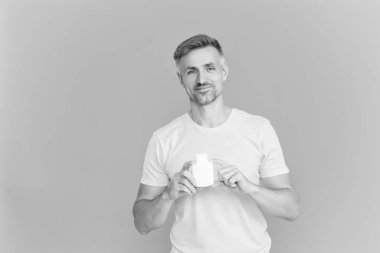 Haplı ya da vitaminli bir adam. Enerji ilacını sunuyorum. Multivitamin ve vitamin. Günlük takviye. İlaç teklif et. Acıyı dindirmek için ilaç. İnsan maviden yiyecek desteğini ayırır..